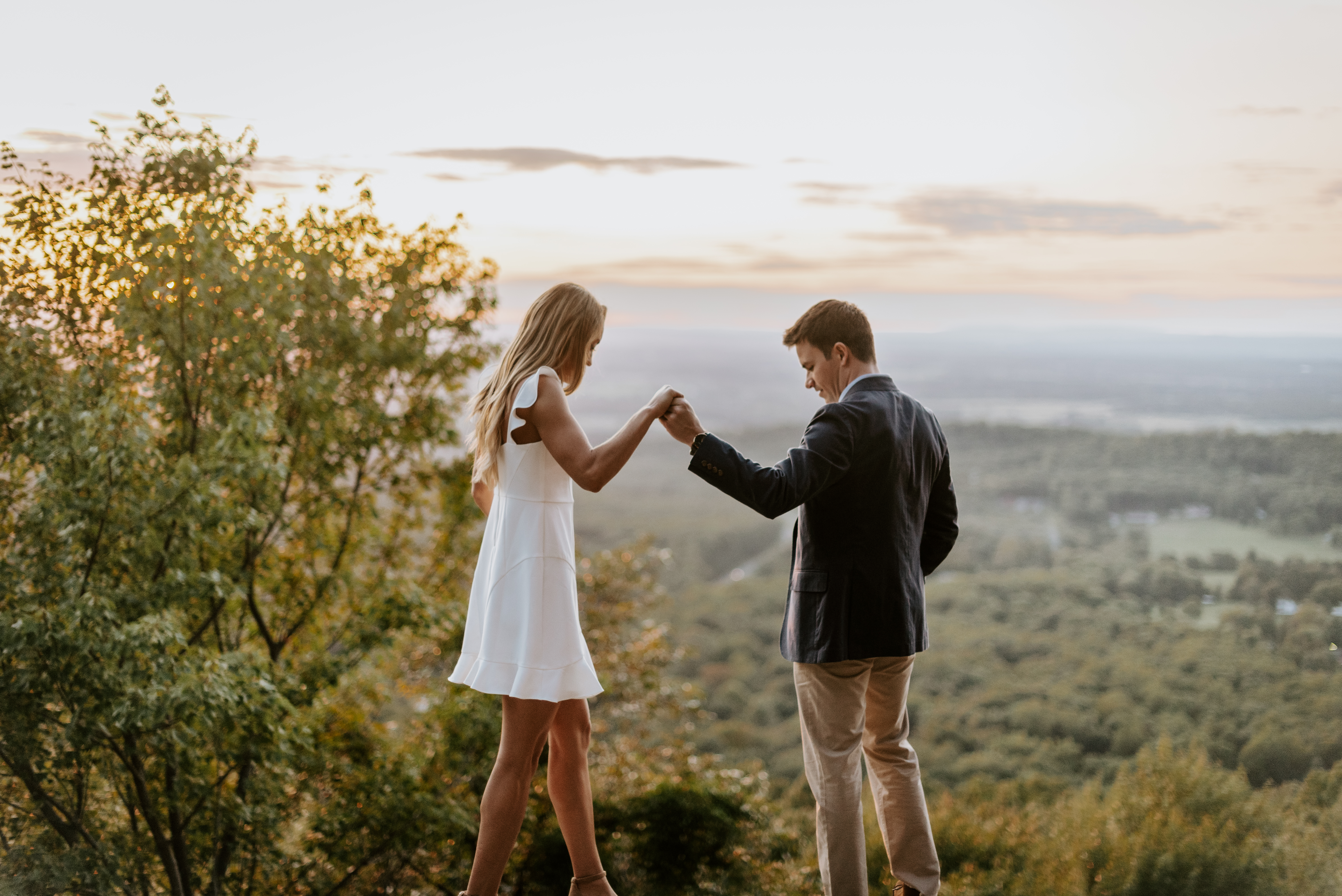 engaged partners holding hands walking across bear's Den Overlook in Bluemont Virginia for their engagement session