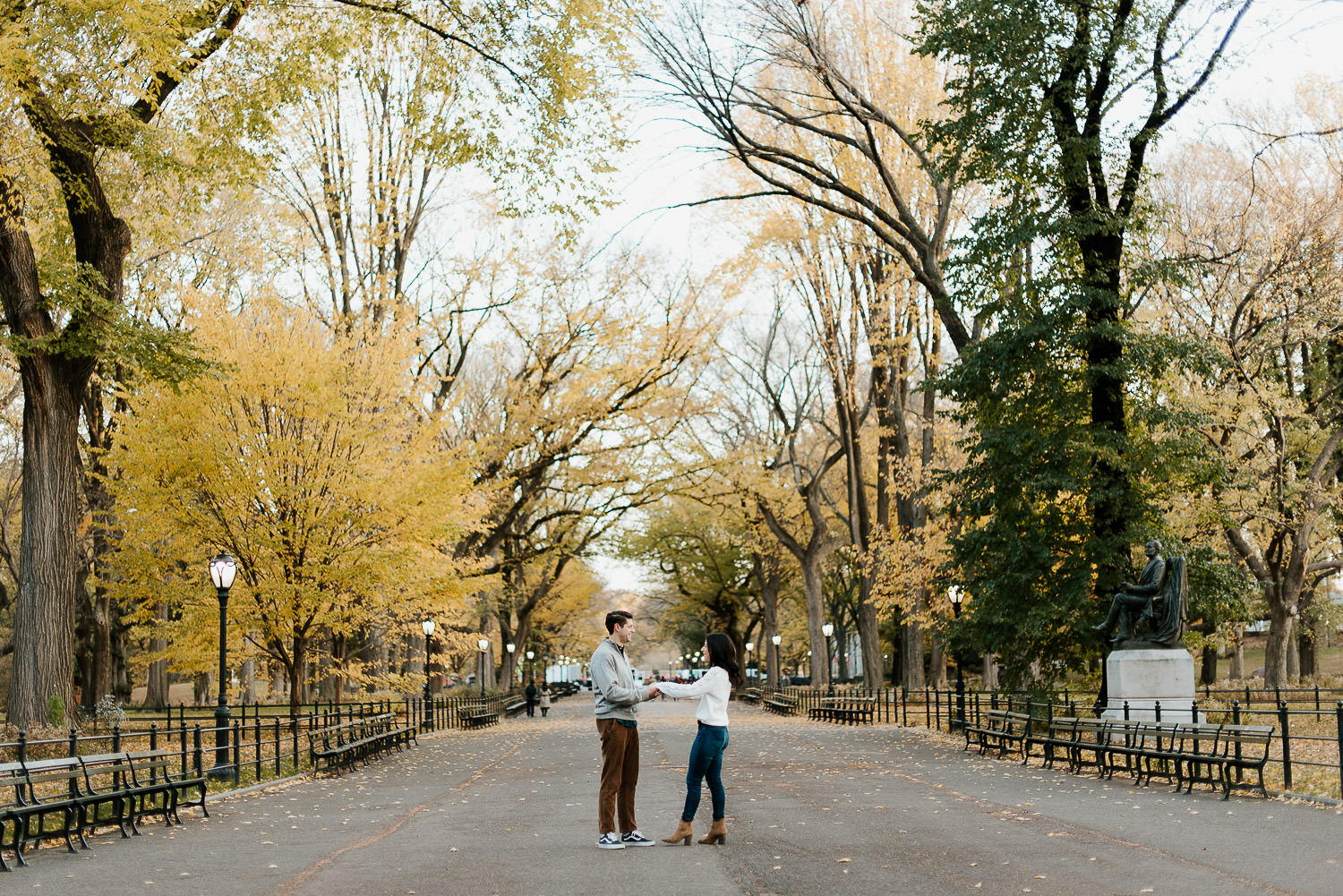 engaged couple holds hands in central park nyc in fall