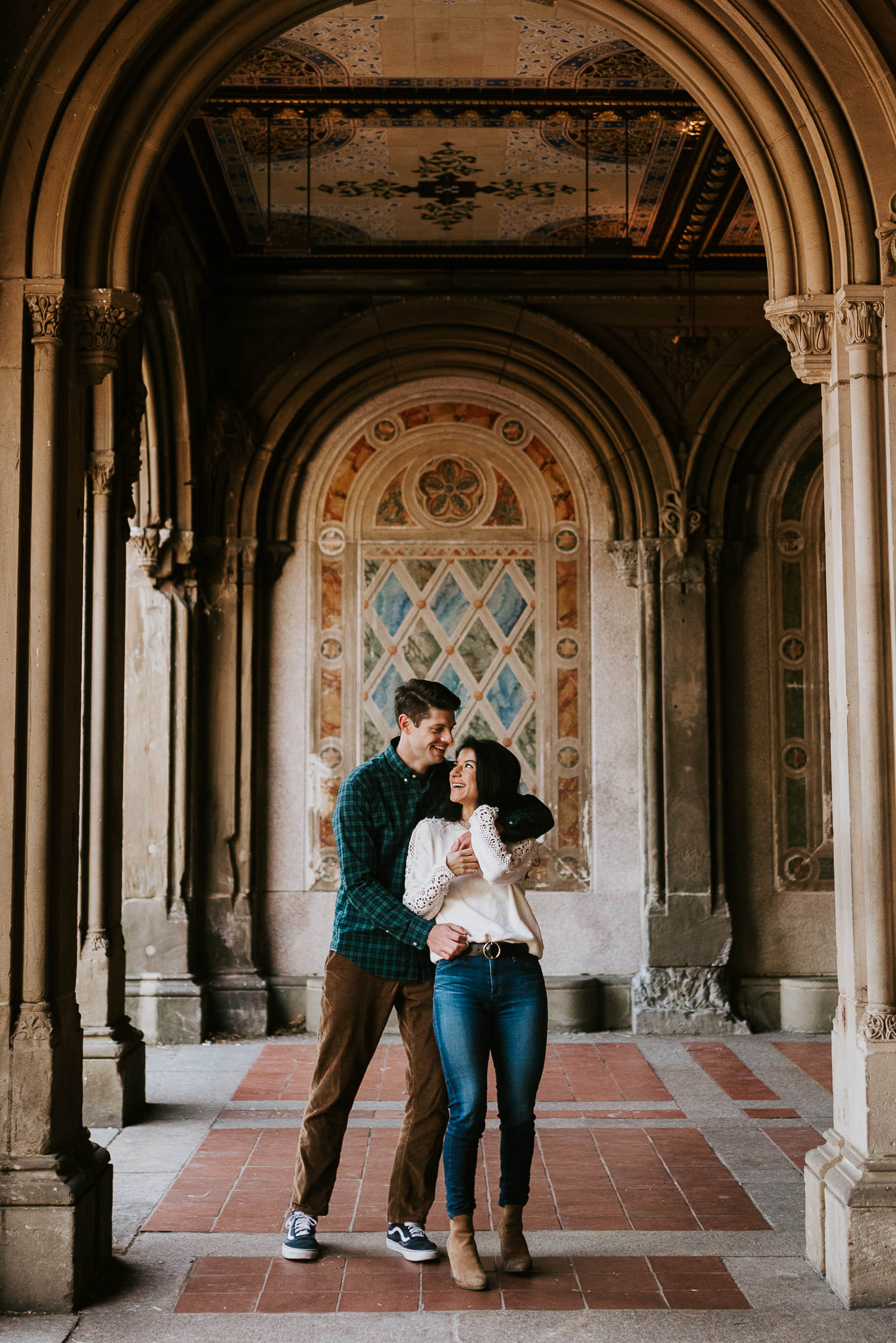 engaged couple hugging in bethesda terrace in central park in nyc