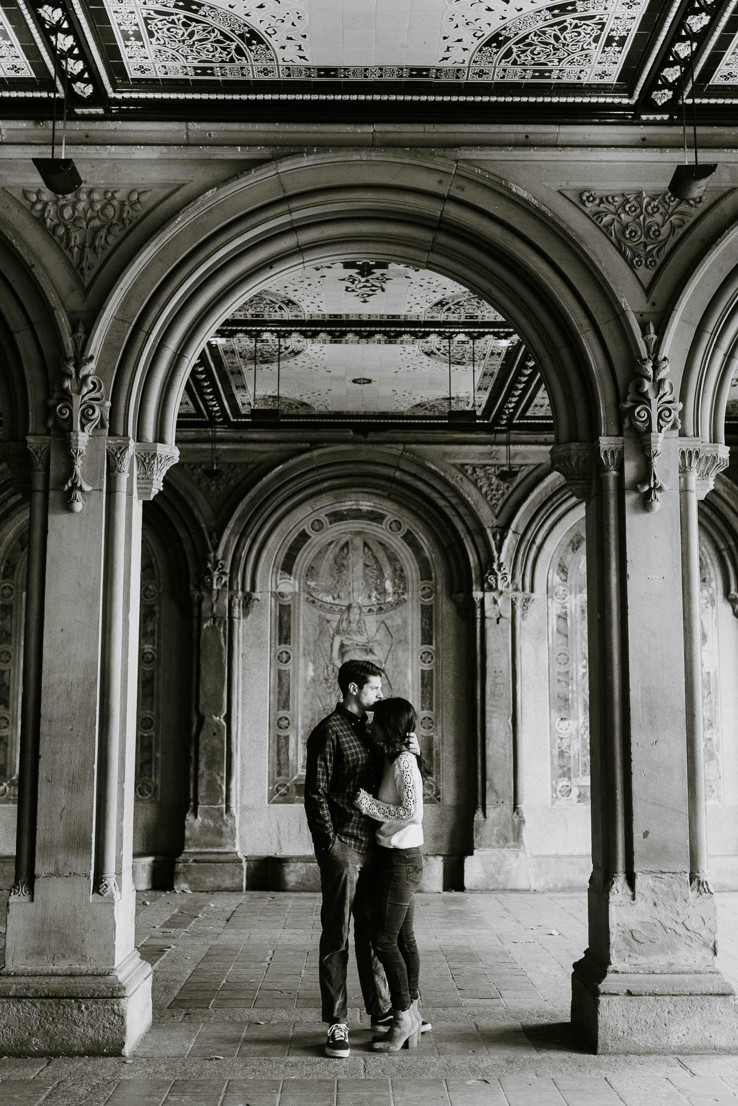 engaged couple during their photoshoot hugging in central park nyc in the fall