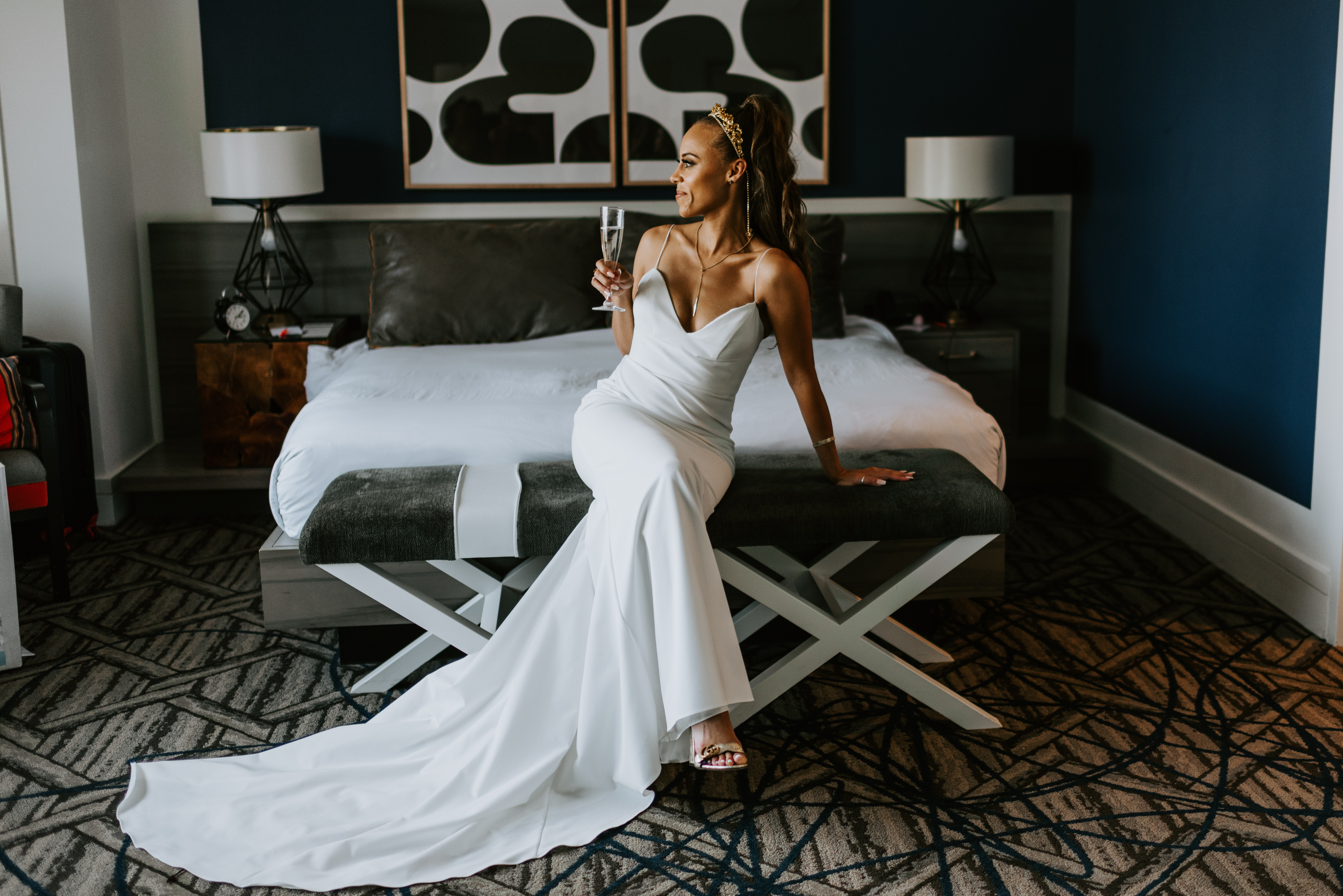 bride sitting on bed at the larz anderson house in washington dc on wedding day in her wedding dress from louvienne